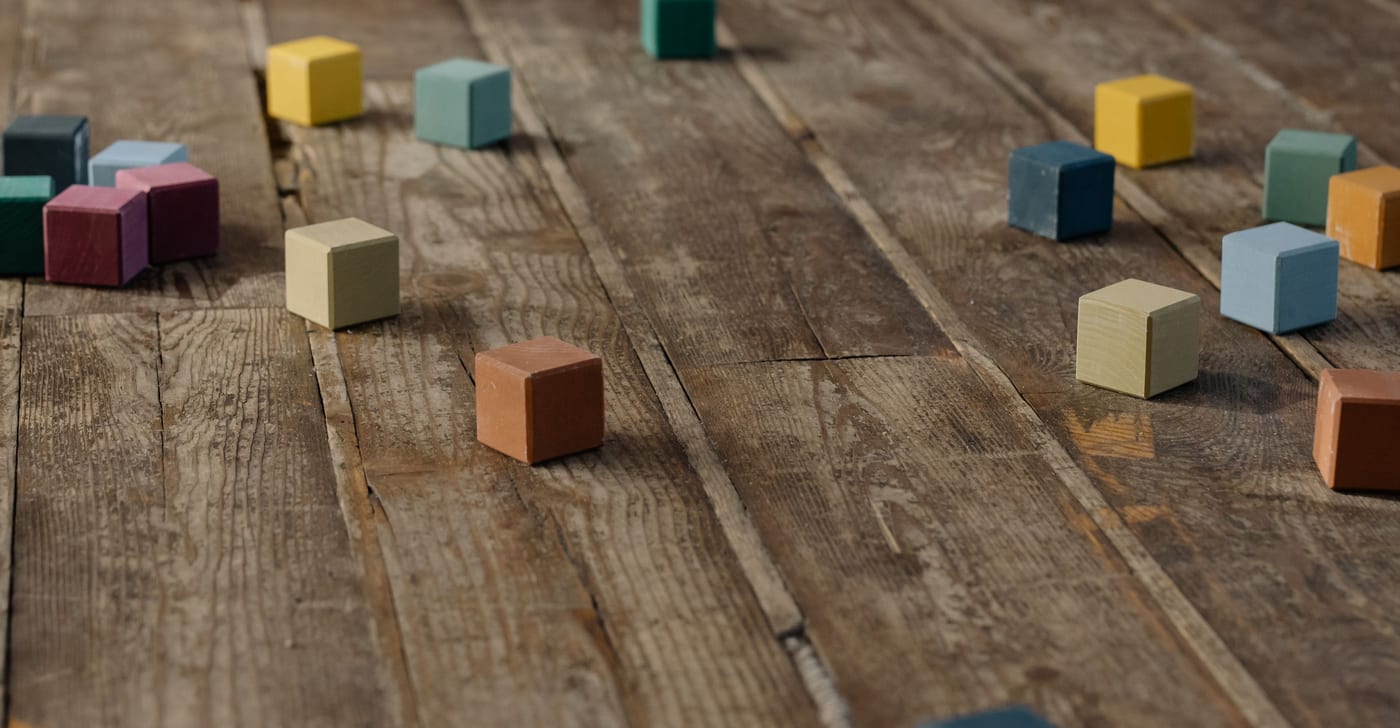 Bloques de madera de colores apagados sobre un piso de tablas antiguas
